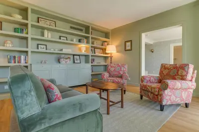a living room with two chairs and a table and shelves at Pestana Quinta Perestrello in Funchal