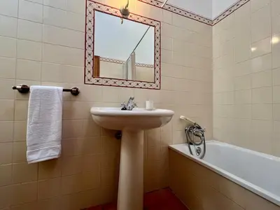 a bathroom with a sink and a mirror and a tub at Entre a Serra e o Mar - Casa das Rosas de Barão in Barão de São João