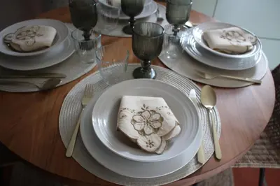 a table with white plates and silverware on a wooden table at Casa dos Lamaceiros in São Vicente
