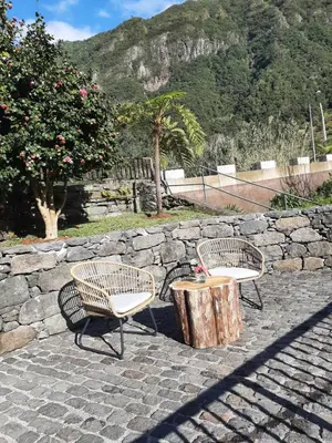 two chairs and a table and a tree stump at Casa dos Lamaceiros in São Vicente