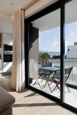 a glass door leading to a balcony with a table at Casa de Viriato in Funchal