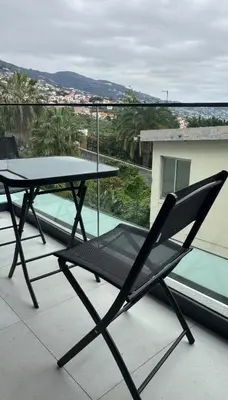 a table and a chair sitting on a balcony at Casa de Viriato in Funchal