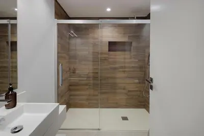 a bathroom with a shower with a glass door at Casa de Viriato in Funchal