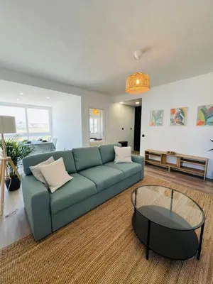 a living room with a blue couch and a glass table at Arrifana Sunrise & Mountain View in Aljezur