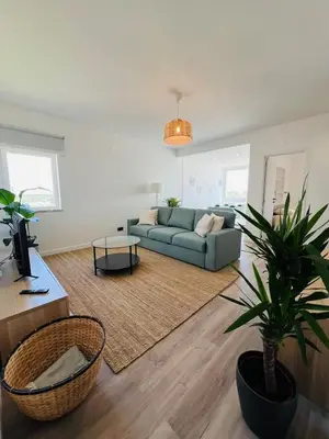 a living room with a couch and a potted plant at Arrifana Sunrise & Mountain View in Aljezur