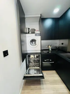 a small kitchen with a washer and a microwave at Arrifana Sunrise & Mountain View in Aljezur