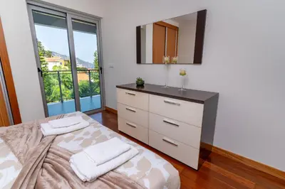 a bedroom with a bed and a mirror at Las Rosas Vista Baia do Funchal in Funchal