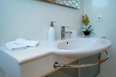 a white sink in a bathroom with a mirror at Las Rosas Vista Baia do Funchal in Funchal
