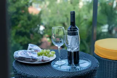 a bottle of wine and a glass on a table at Las Rosas Vista Baia do Funchal in Funchal