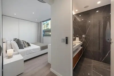 a bedroom with a bed and a bathroom at Maravilhas I by An Island Apart in Funchal
