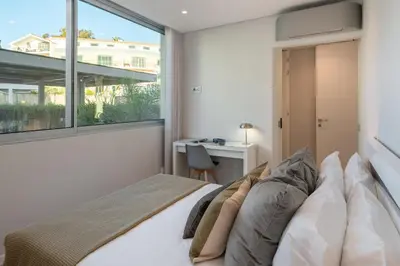 a bedroom with a bed and a window and a desk at Maravilhas I by An Island Apart in Funchal