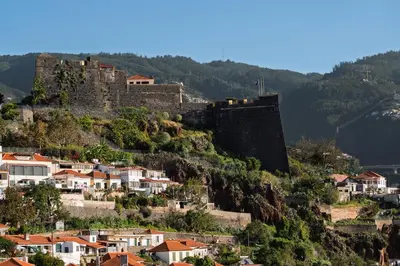 a castle on top of a hill with houses at Maravilhas I by An Island Apart in Funchal