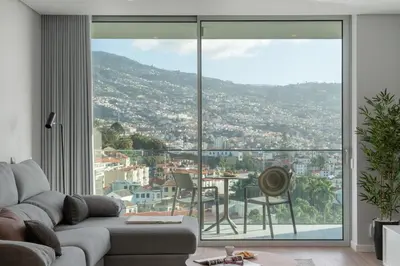 a living room with a couch and a large glass window at Maravilhas I by An Island Apart in Funchal