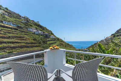 a balcony with two chairs and the ocean at Atlantic Lookout by Atlantic Holiday in Calheta
