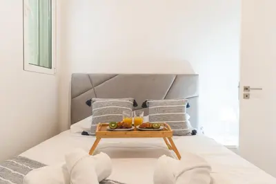 a tray of fruit on a bed with two glasses of orange juice at Atlantic Lookout by Atlantic Holiday in Calheta
