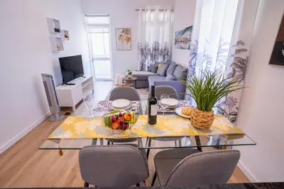 a living room with a glass table and chairs at Sol do Lido, esplendor do Funchal in Funchal