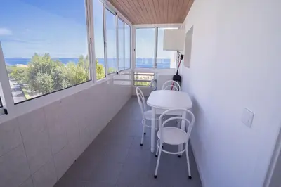 a bathroom with a table and chairs and windows at Sol do Lido, esplendor do Funchal in Funchal
