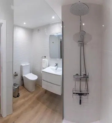 a white bathroom with a toilet and a sink at Sol do Lido, esplendor do Funchal in Funchal
