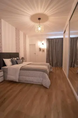 a bedroom with a large bed and a chandelier at Sol do Lido, esplendor do Funchal in Funchal