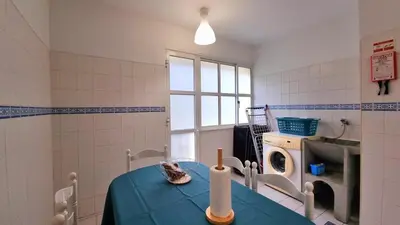 a room with a blue table and a washing machine at Perfume a Maresia in Câmara de Lobos
