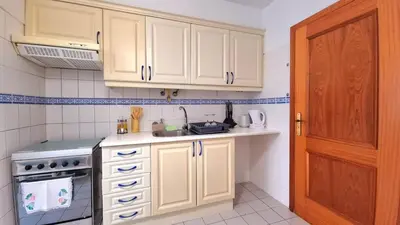 a kitchen with white cabinets and a sink at Perfume a Maresia in Câmara de Lobos