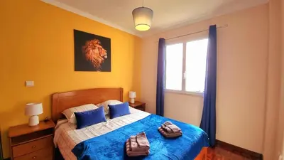 a bedroom with a bed with blue sheets and a window at Perfume a Maresia in Câmara de Lobos