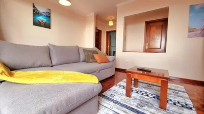 a living room with a couch and a table at Perfume a Maresia in Câmara de Lobos
