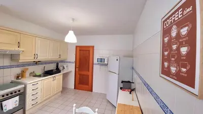 a kitchen with a refrigerator and a chalkboard on the wall at Perfume a Maresia in Câmara de Lobos