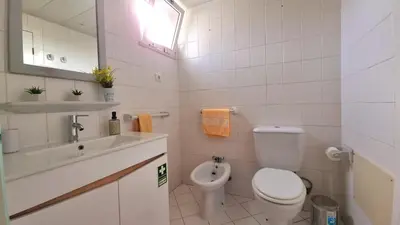 a white bathroom with a toilet and a sink at Perfume a Maresia in Câmara de Lobos