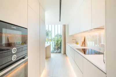 a kitchen with white cabinets and a large window at Savoy Monumentalis your home in Madeira Island in Funchal