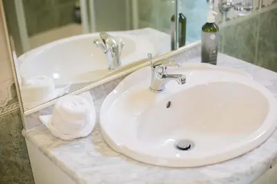 a bathroom with a white sink and a mirror at Casa Terra da Vinha in Canhas