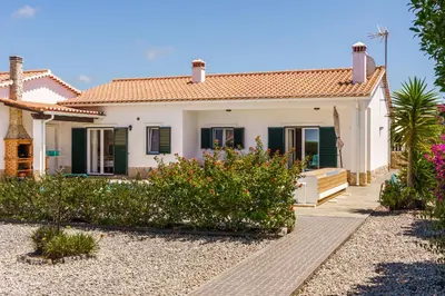 a white house with green shutters at Sunny Ocean Villa with pool near Arrifana beach in Aljezur