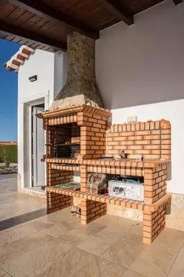 a brick fireplace on the side of a house at Sunny Ocean Villa with pool near Arrifana beach in Aljezur