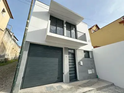a white house with a garage door and a balcony at City Center House in Funchal