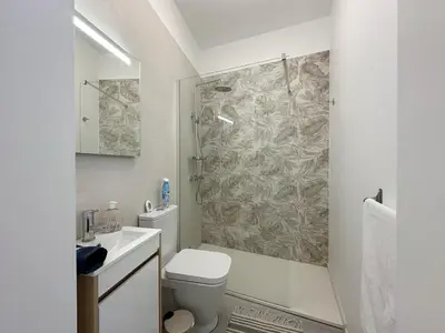 a white bathroom with a toilet and a shower at City Center House in Funchal