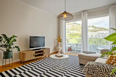 a living room with a tv and a couch at Refúgio Girassol in Caniço