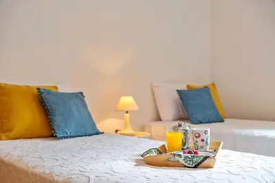 a hotel room with two beds and a tray with a drink at Refúgio Girassol in Caniço
