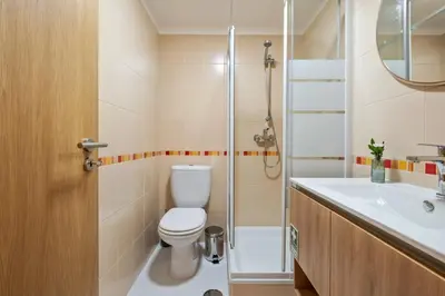 a bathroom with a toilet and a sink and a shower at Refúgio Girassol in Caniço