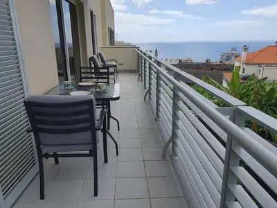 a balcony with chairs and a table on a balcony at Aqua Vista Lido Apartment in Funchal
