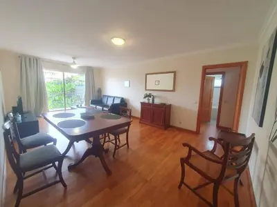 a living room with a dining room table and chairs at Aqua Vista Lido Apartment in Funchal