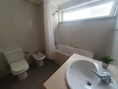 a bathroom with a sink and a toilet and a window at Aqua Vista Lido Apartment in Funchal