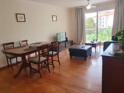 a living room with a table and chairs and a couch at Aqua Vista Lido Apartment in Funchal