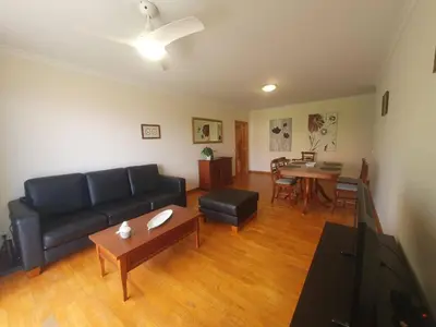 a living room with a black couch and a table at Aqua Vista Lido Apartment in Funchal