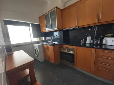 a kitchen with wooden cabinets and a dishwasher at Jose's Place Holiday Apartment in Funchal