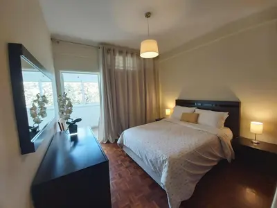 a bedroom with a bed and a large window at Jose's Place Holiday Apartment in Funchal