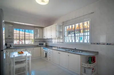 a white kitchen with a refrigerator and a sink at Casa Bom Sucesso in Funchal