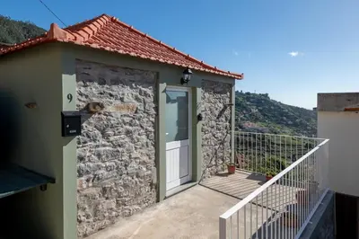 a stone house with a door and a balcony at Casa Morena - Private Tropical Oasis in Campanário