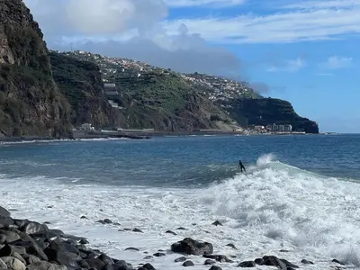 a person riding a wave on a surfboard in the water at Casa Morena - Private Tropical Oasis in Campanário