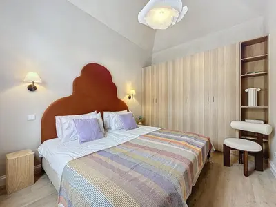 a bedroom with a large bed and a chair at THE BOAT HOUSE Sea Front and Private Pool in Funchal