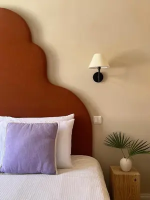 a bedroom with a bed with a wooden headboard and a lamp at THE BOAT HOUSE Sea Front and Private Pool in Funchal